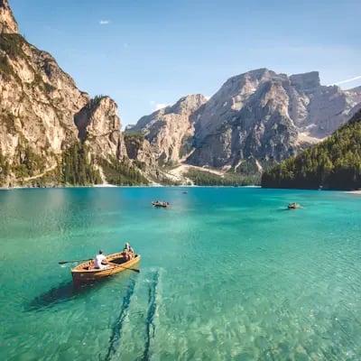 Rowing boat on a turquoise lake surrounded by mountains